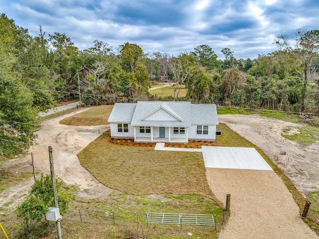 view of front of home with driveway, covered porch, and a front yard