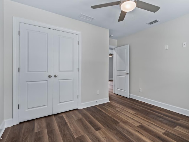 unfurnished bedroom with baseboards, visible vents, dark wood finished floors, and a closet