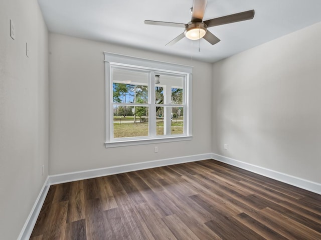 unfurnished room featuring baseboards, dark wood finished floors, and a ceiling fan