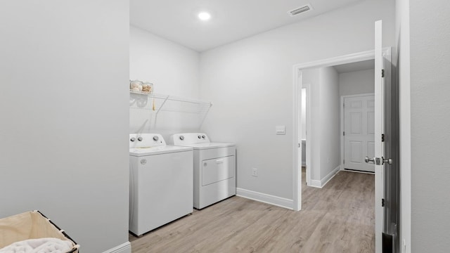 washroom featuring washer and clothes dryer and light hardwood / wood-style flooring