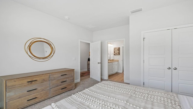 carpeted bedroom featuring ensuite bath and a closet