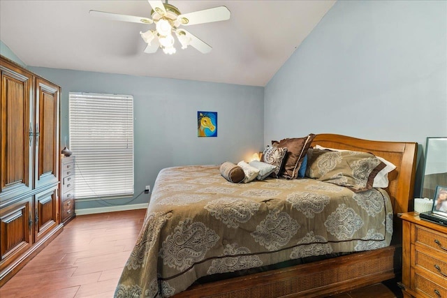 bedroom featuring hardwood / wood-style flooring, ceiling fan, and vaulted ceiling