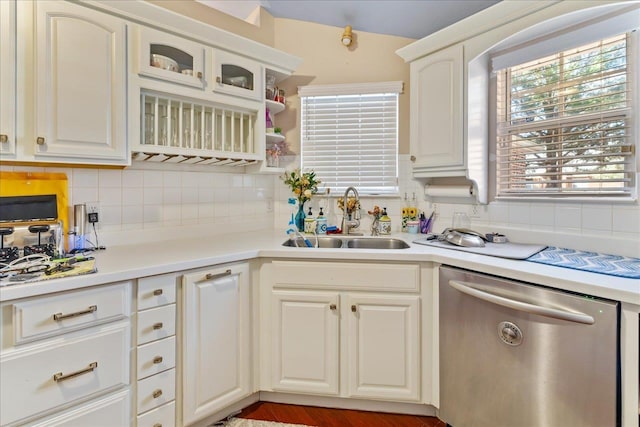 kitchen featuring tasteful backsplash, dishwasher, white cabinets, and sink