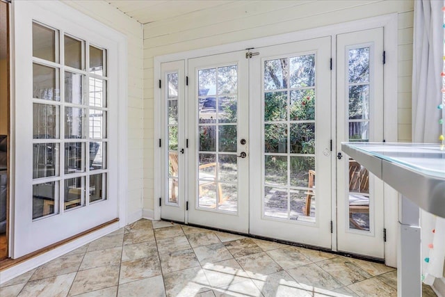 entryway featuring french doors and wood walls