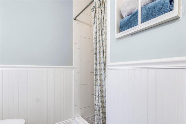 full bath with a stall shower and wainscoting