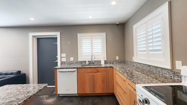 kitchen featuring sink, white appliances, and dark stone countertops