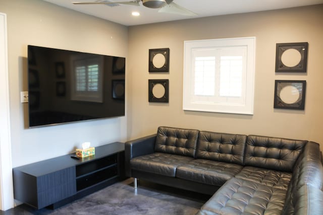 living room with ceiling fan and carpet