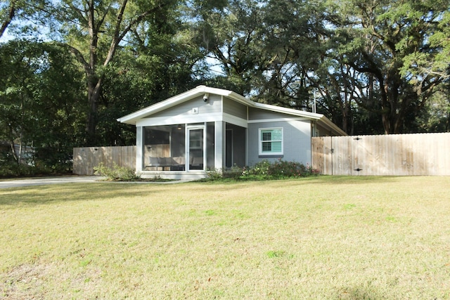 view of front of home featuring a front yard and a sunroom