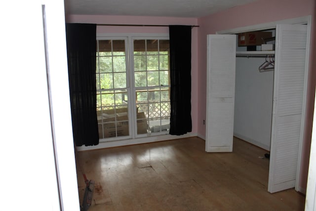 unfurnished bedroom with light wood finished floors and a closet