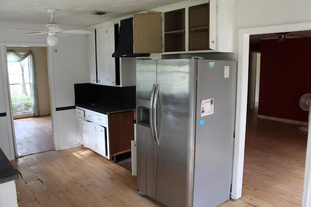 kitchen with dark countertops, stainless steel fridge, and light wood-style flooring