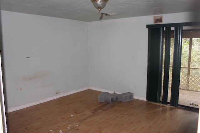 unfurnished room featuring dark wood-type flooring and baseboards