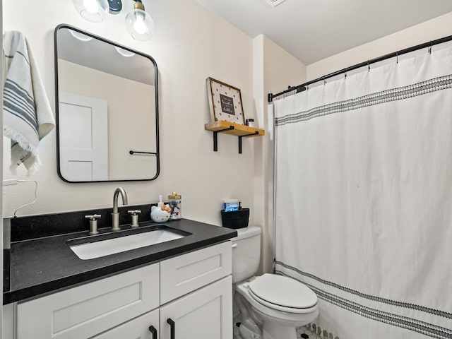 bathroom featuring a shower with curtain, vanity, and toilet