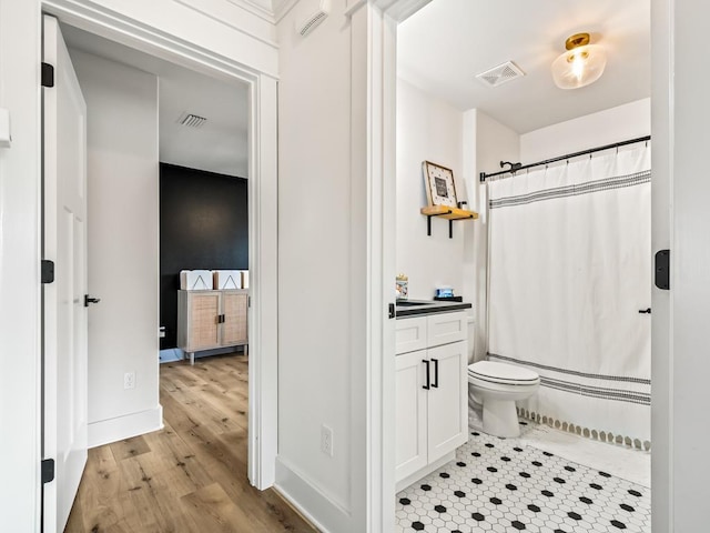 bathroom with vanity, hardwood / wood-style flooring, toilet, and curtained shower