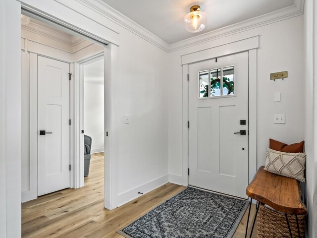 entryway with crown molding and light hardwood / wood-style floors