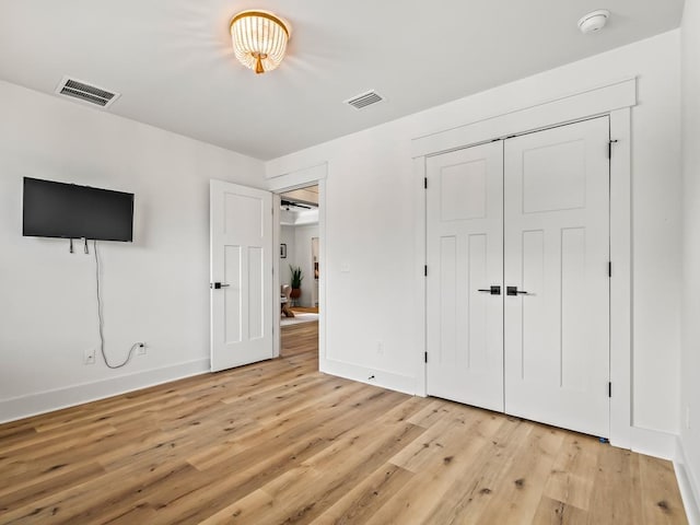 unfurnished bedroom featuring light hardwood / wood-style floors and a closet