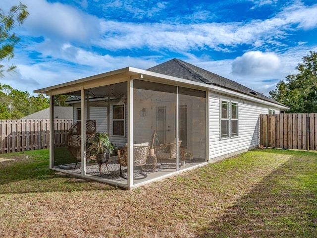 rear view of house featuring a sunroom, a yard, ceiling fan, and a patio