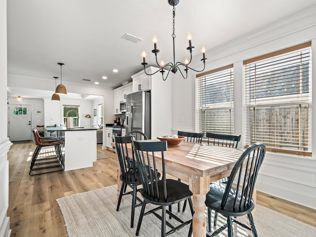 dining space featuring a chandelier, light hardwood / wood-style flooring, and plenty of natural light