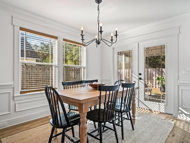 dining space featuring a chandelier, hardwood / wood-style flooring, and ornamental molding