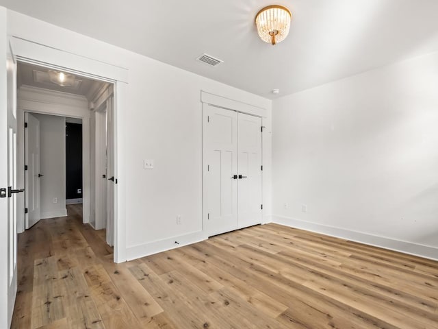 unfurnished bedroom featuring light hardwood / wood-style floors and a closet