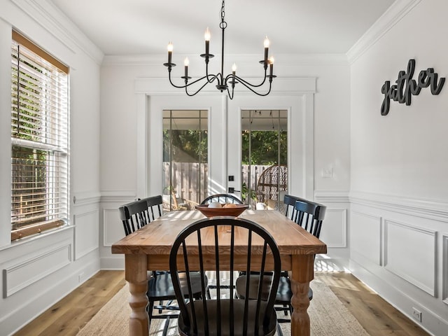 dining room with crown molding, a chandelier, and light wood-type flooring