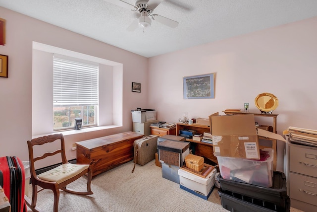 home office with a ceiling fan, carpet, and a textured ceiling