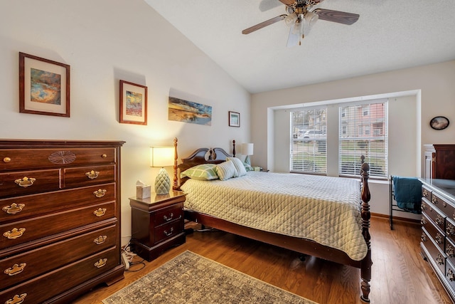 bedroom with baseboards, a ceiling fan, lofted ceiling, and wood finished floors