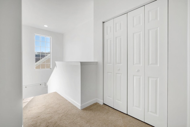 hall featuring light colored carpet