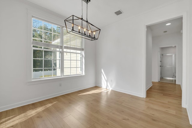 unfurnished dining area featuring a chandelier and light wood-type flooring