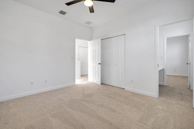 unfurnished bedroom with ceiling fan, a closet, and light carpet