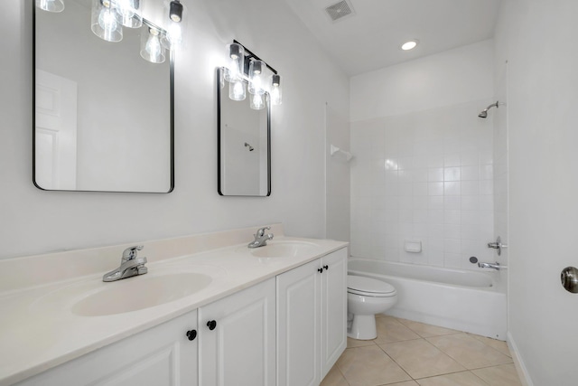 full bathroom with tile patterned flooring, vanity, tiled shower / bath combo, and toilet