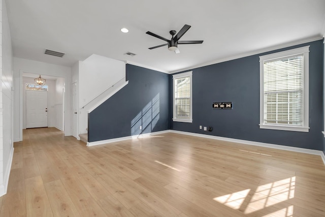 unfurnished living room with ceiling fan with notable chandelier, light hardwood / wood-style floors, and ornamental molding