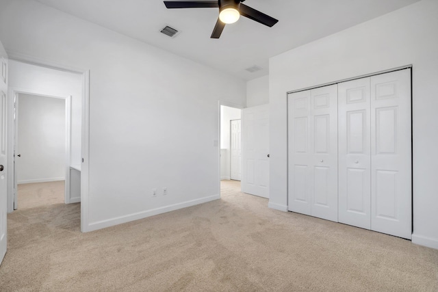 unfurnished bedroom featuring a closet, light colored carpet, and ceiling fan