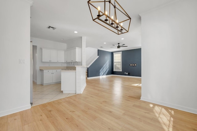 interior space featuring light hardwood / wood-style floors and ceiling fan with notable chandelier