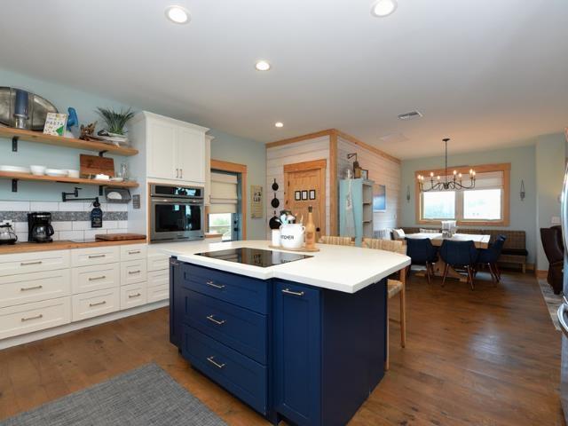 kitchen with white cabinetry, hanging light fixtures, white refrigerator, oven, and black electric stovetop