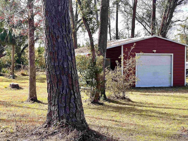 view of yard featuring a garage and an outbuilding