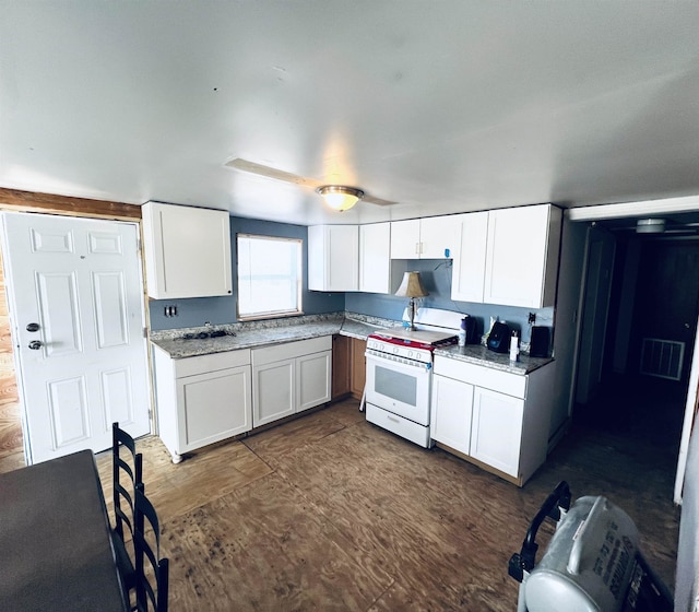 kitchen featuring white cabinets, white range, and light stone countertops