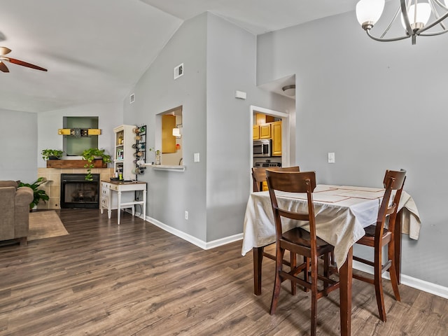31 Sioux Trl, Crawfordville, FL 32327 - dining space featuring a ceiling fan, wood finished floors, a chandelier, a tiled fireplace, and high vaulted ceiling