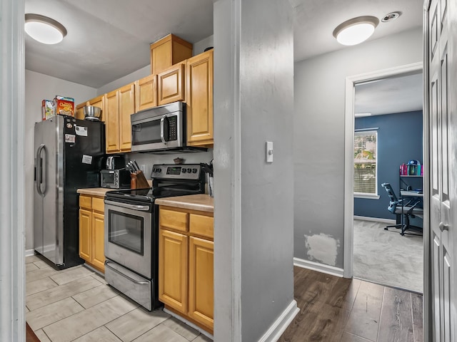 31 Sioux Trl, Crawfordville, FL 32327 - kitchen with stainless steel appliances, light wood-style floors, an office area, and light countertops