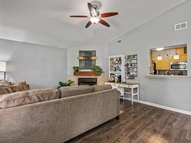 31 Sioux Trl, Crawfordville, FL 32327 - living area with a ceiling fan, vaulted ceiling, dark wood finished floors, and a tiled fireplace