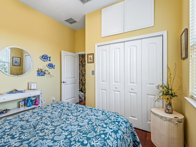 bedroom with dark hardwood / wood-style floors and a closet