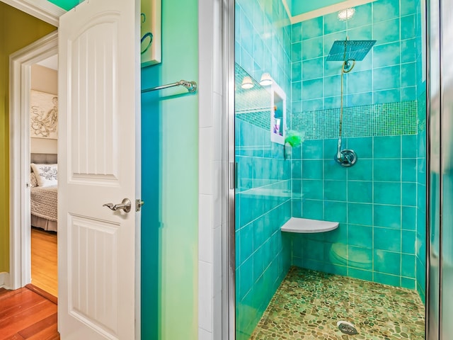 bathroom featuring wood-type flooring and a shower with shower door