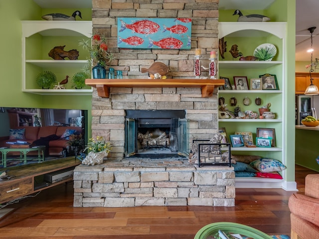 living room with a stone fireplace and hardwood / wood-style floors