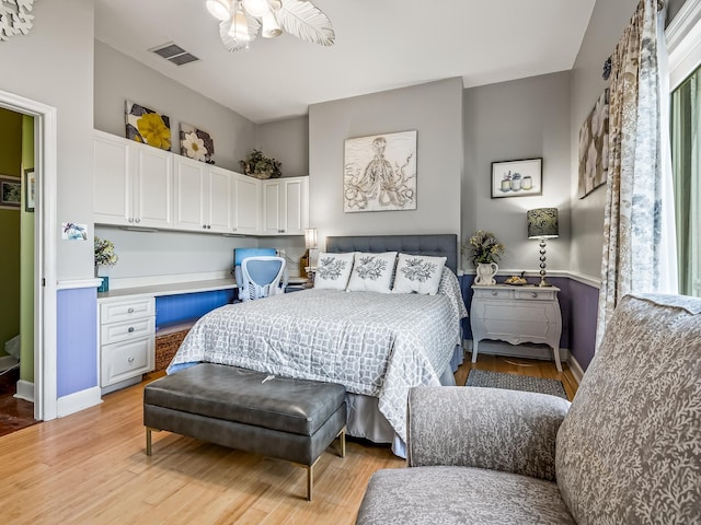 bedroom featuring light hardwood / wood-style flooring and built in desk