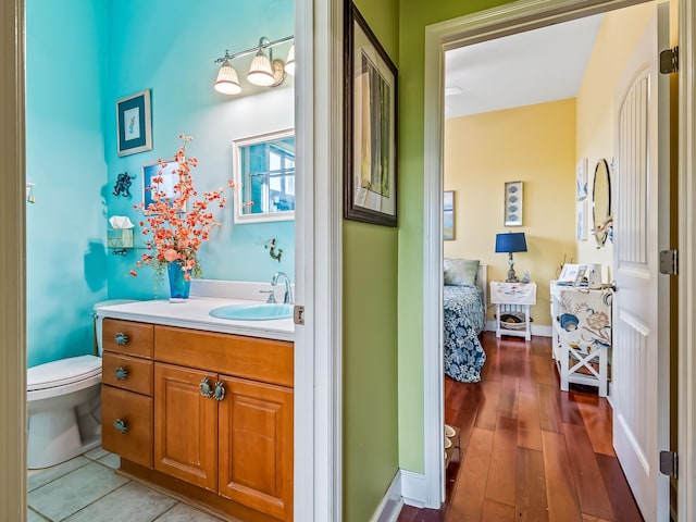 bathroom featuring hardwood / wood-style flooring, vanity, and toilet