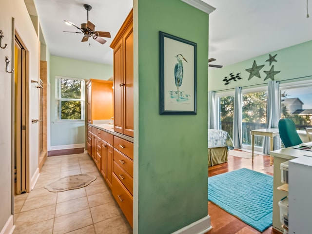 interior space featuring ceiling fan, tile patterned floors, an enclosed shower, and vanity