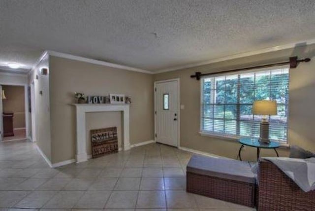 tiled entrance foyer featuring ornamental molding and a textured ceiling