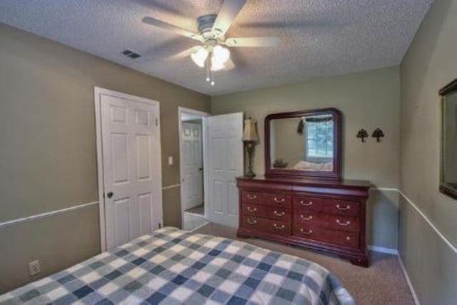 carpeted bedroom with a textured ceiling and ceiling fan