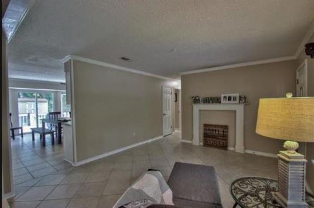 living room with a textured ceiling, light tile patterned floors, and ornamental molding