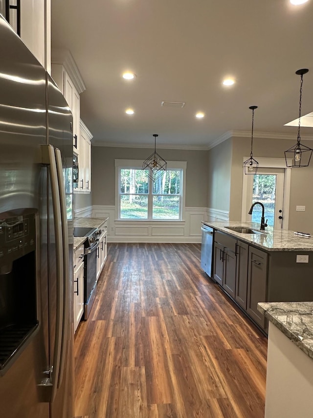 2725 Masterson Ln, Tallahassee, FL 32311 - kitchen featuring light stone counters, a wealth of natural light, hanging light fixtures, appliances with stainless steel finishes, and a sink