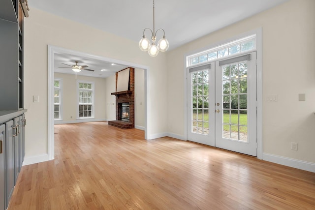 332 Winnstead Ct, Tallahassee, FL 32312 - unfurnished living room with healthy amount of natural light, light wood-style floors, a brick fireplace, and french doors